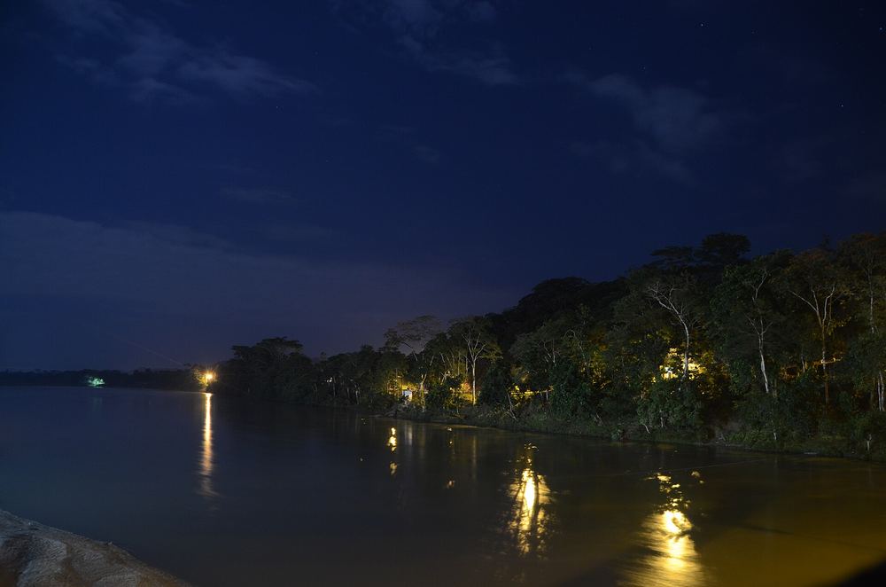 Orilla del río amazónico iluminada durante la noche